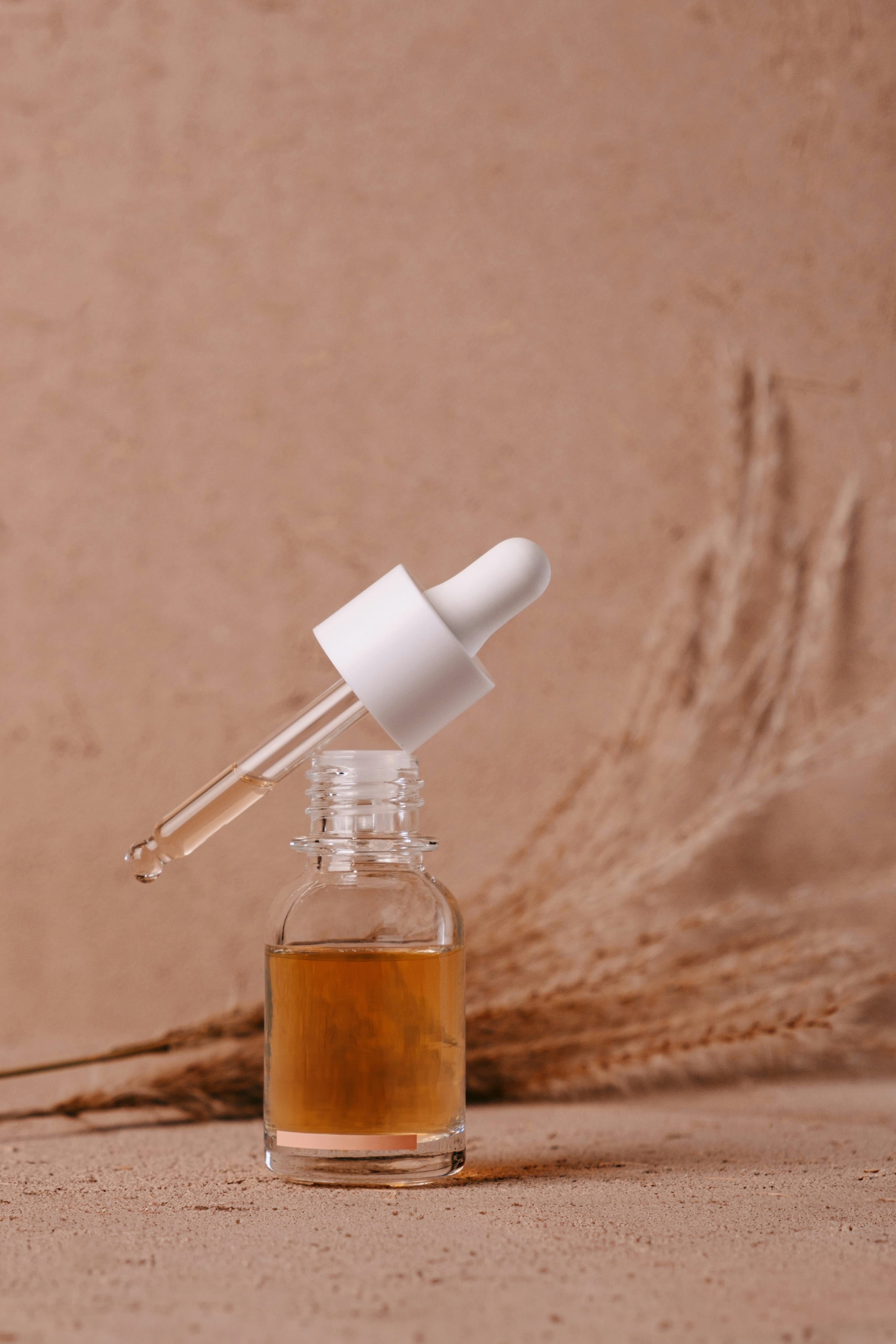 Premium serum w szklanym dropperze na terakotowym tle